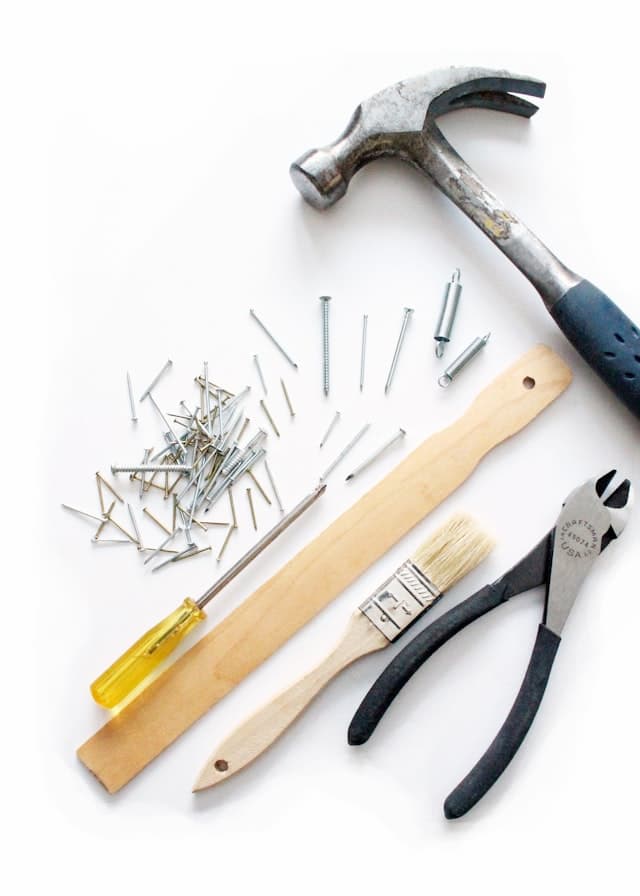 Garage door repair tools and a replacement spring laid out on a workbench