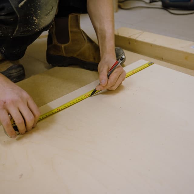 Technician inspecting and measuring garage door hardware during a tune-up