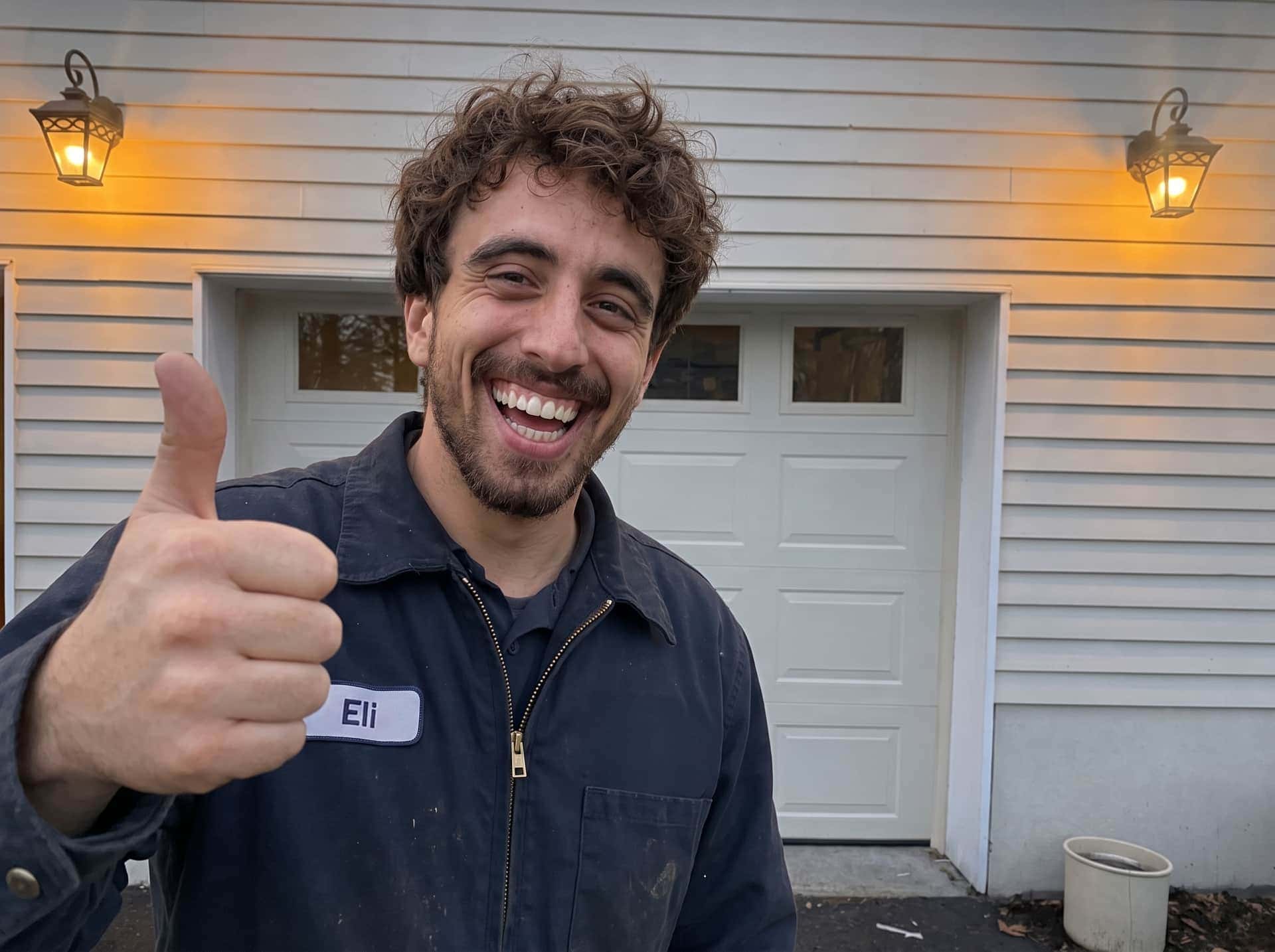 Eli, a Garage Door USA technician, smiling after a completed garage door repair